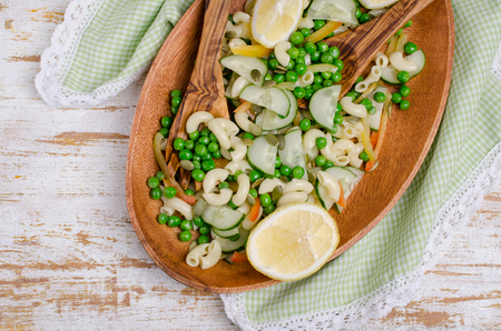 Salad with pasta and fresh vegetables on wooden background. Selective focus.の写真素材