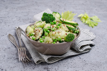 Salad with quinoa and slices of fresh green vegetables in a bowl on the table. Selective focus.の写真素材