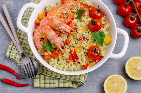 Couscous with vegetables and shrimp in a dish on the table. Selective focus.の写真素材