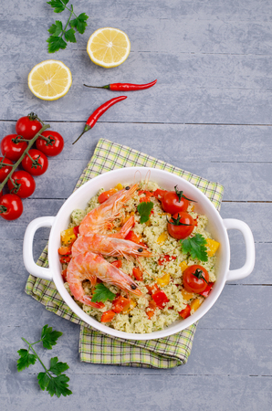 Couscous with vegetables and shrimp in a dish on the table. Selective focus.の写真素材