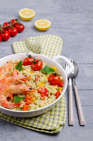 Couscous with vegetables and shrimp in a dish on the table. Selective focus.の写真素材
