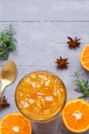 Traditional tangerine jam with spices in glass on wooden background. Selective focus.の写真素材