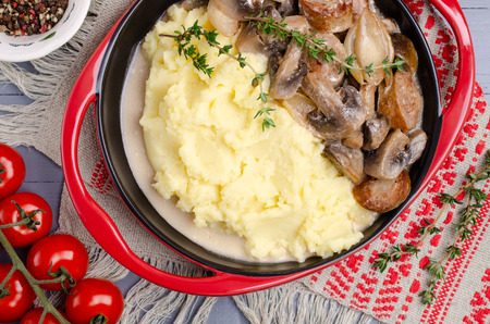 Mashed potatoes and slices of mushrooms with sausages in sauce. Selective focus.の写真素材