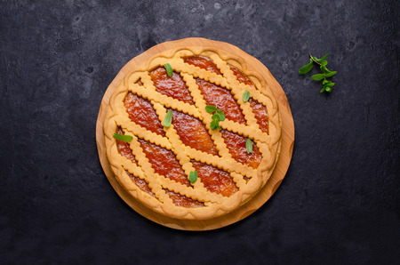 Round tart of shortbread and jam on a dark slate background. Selective focus.の写真素材