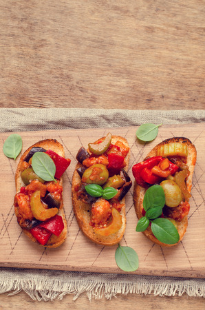 Bruschetta with stewed vegetables and Basil on a wooden background. Selective focus.の写真素材
