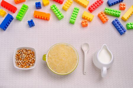 Corn baby porridge in a ceramic dish on a textile background. Selective focus.の写真素材