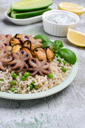 Seafood with brown rice and green peas in the dish. Selective focus.の写真素材