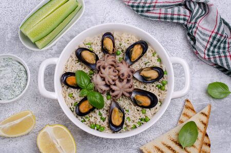 Seafood with brown rice and green peas in the dish. Selective focus.の写真素材