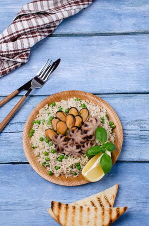 Seafood with brown rice and green peas in the dish. Selective focus.の写真素材