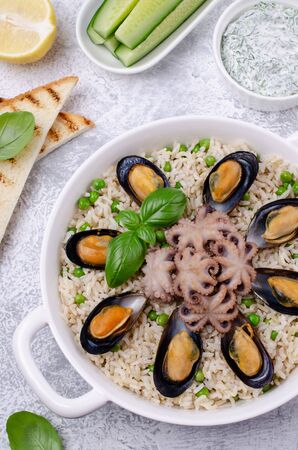 Seafood with brown rice and green peas in the dish. Selective focus.の写真素材