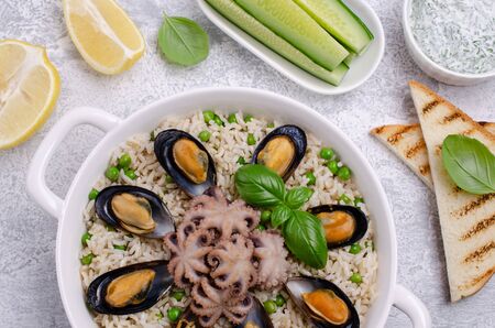 Seafood with brown rice and green peas in the dish. Selective focus.の写真素材