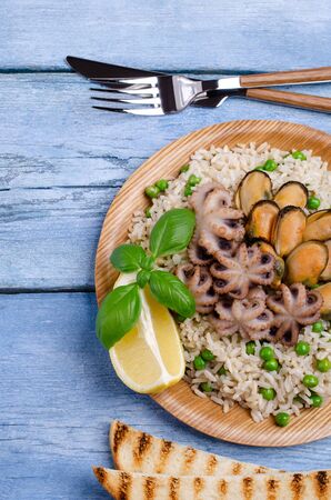 Seafood with brown rice and green peas in the dish. Selective focus.の写真素材