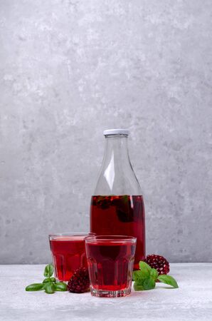 Transparent red drink in glass on grey background. Selective focus.の写真素材
