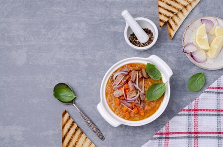 Thick soup with lentils, slices of meat and vegetables in a dish on a wooden background. Selective focus.の写真素材