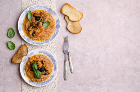 Red lentils with fried seafood and black caviar in a dish on a slate background. Selective focus.の写真素材