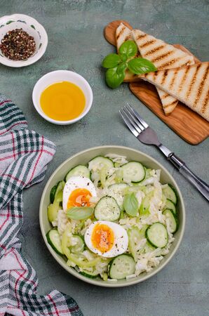 Salad of raw vegetables with boiled eggs in a bowl on a slate background. Selective focus.の写真素材