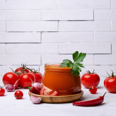 Homemade canned red sauce in a glass jar with vegetables. Selective focus.の写真素材