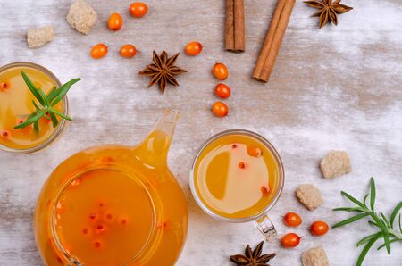 Vitamin healthy sea buckthorn tea in glass with spices on a wooden background. Selective focus.の写真素材