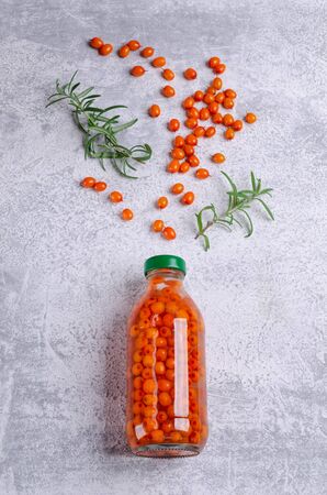 Sea buckthorn infused water in glass with rosemary branches on a slate background. Selective focus.の写真素材