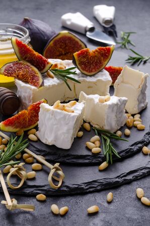 Cheese with white mold with figs, nuts and honey on a slate background. Selective focus.の写真素材