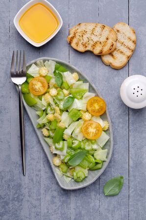 Salad of raw vegetables in a dish on a wooden background. Selective focus.の写真素材