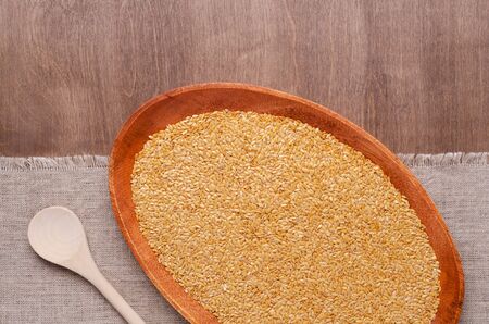 White flax seeds in a bowl. Wooden background and textiles. Selective focus.の写真素材