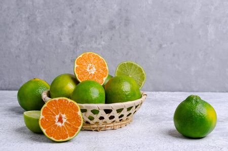Raw green tangerine in a box on a gray slate background. Selective focus.の写真素材