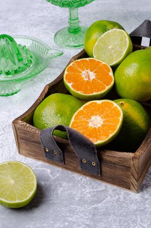 Raw green tangerine in a box on a gray slate background. Selective focus.の写真素材