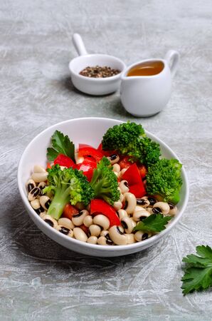 Salad beans with vegetables in a ceramic dish on a slate background. Selective focus.の写真素材