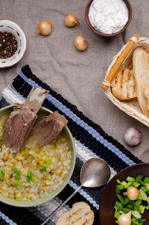 Pearl barley soup with vegetables and meat in a dish on a textile background. Selective focus.の写真素材