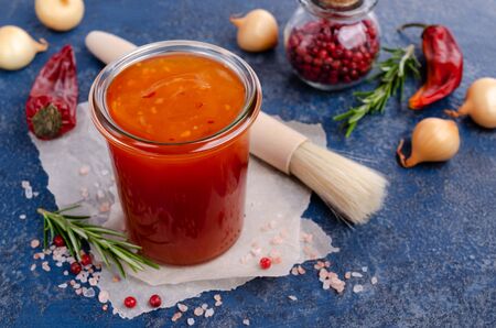 Homemade barbecue sauce in glass with a brush on a slate background. Selective focus.の写真素材