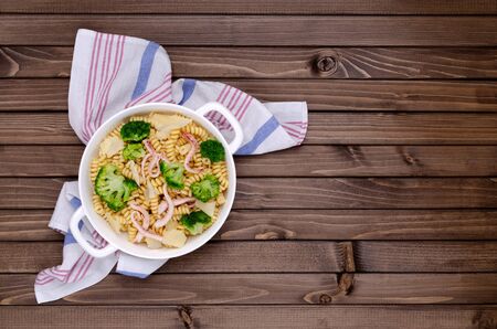 Pasta with seafood, broccoli and cheese in a dish on a wooden background. Selective focus.の写真素材