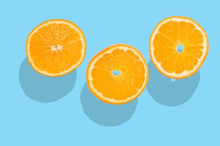 Orange fruit slices on a blue background. Design concept.の写真素材
