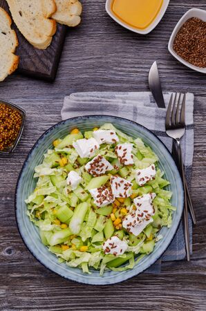 Vegetable salad with feta cheese and flax seeds on a wooden background. Selective focus.の写真素材
