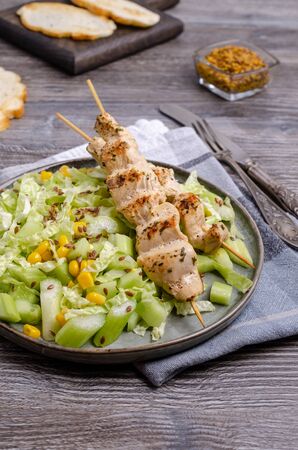 Roast kebab meat with a salad of raw vegetables in a dish on a wooden background. Selective focus.の写真素材
