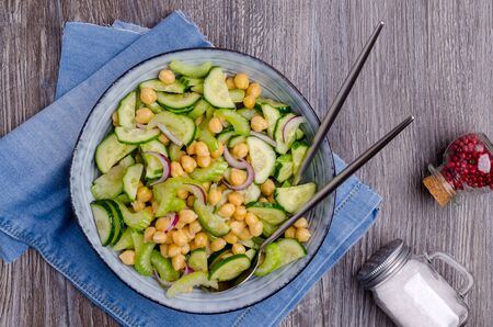 Salad raw vegetables with chickpeas in a dish on a wooden background. Selective focus.の写真素材