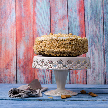 Round layer cake with nuts on a blue wooden background. Selective focus.の写真素材