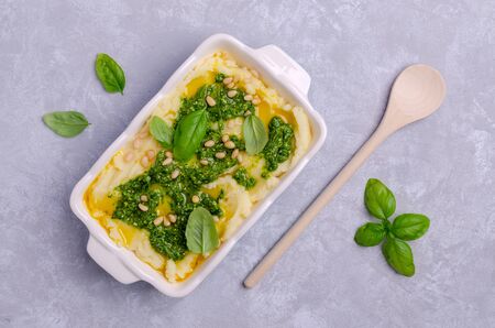 Mashed potatoes with green sauce and nuts in a dish on a slate background. Selective focus.の写真素材
