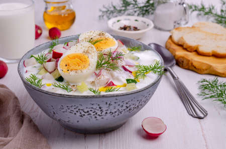 Cold soup with raw vegetables and eggs in a dish on a wooden background. Selective focus.の写真素材