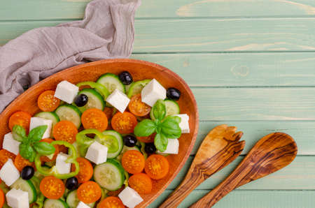 Salad raw vegetables and cheese in a dish on a wooden background. Selective focus.の写真素材