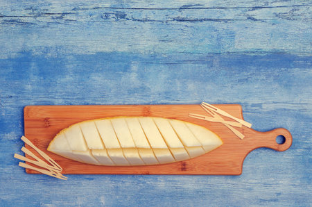 Slices of raw melon on an old blue wooden background. Design concept. Selective focus.