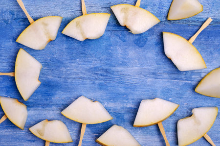Slices of raw melon on an old blue wooden background. Design concept. Selective focus.