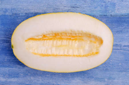Slices of raw melon on an old blue wooden background. Design concept. Selective focus.の写真素材