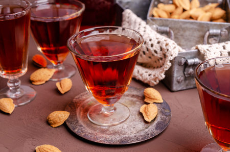 Traditional brown almond liquid in a glass on a stone background. Selective focus.