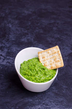 Green sauce in a ceramic bowl on a dark background. Selective focus.の写真素材
