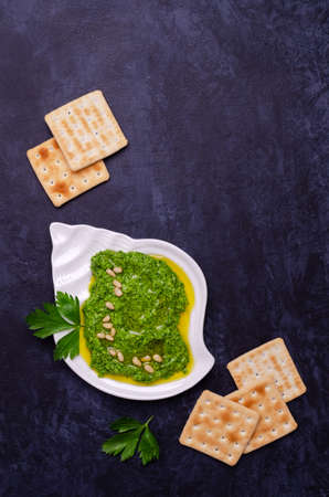 Green sauce in a ceramic bowl on a dark background. Selective focus.の写真素材