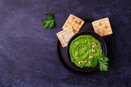 Green sauce in a ceramic bowl on a dark background. Selective focus.の写真素材