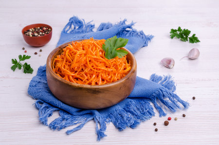 Salad of chopped spiced carrots in a dish on a light wooden background. Selective focus.の写真素材