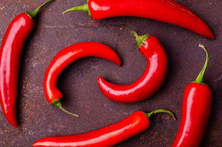 Red pepper pod on a rusty brown metal background. Design concept. Selective focus.