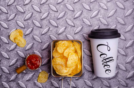 Potato chips in a basket on a metal background. Selective focus.の写真素材